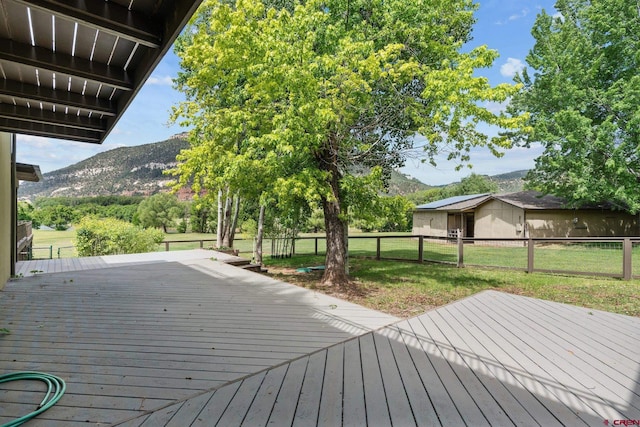 deck featuring a lawn and a mountain view