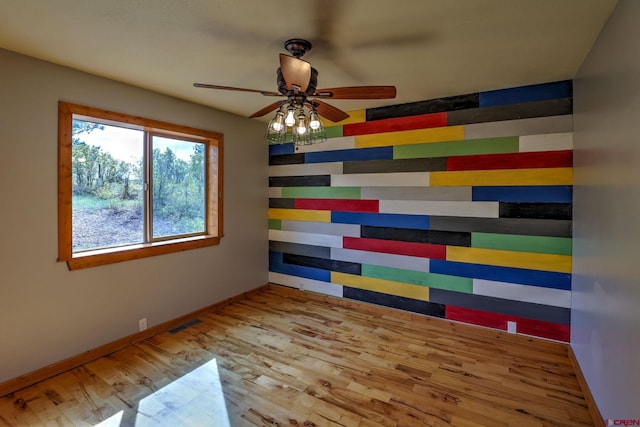 empty room with ceiling fan and light hardwood / wood-style flooring