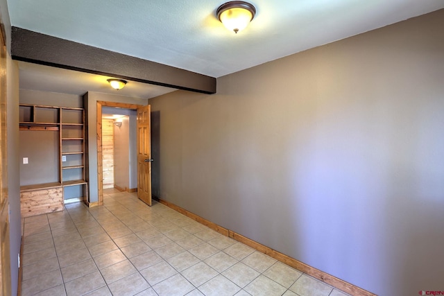 tiled spare room featuring a textured ceiling