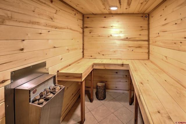 view of sauna / steam room featuring tile patterned floors, wooden walls, and wooden ceiling