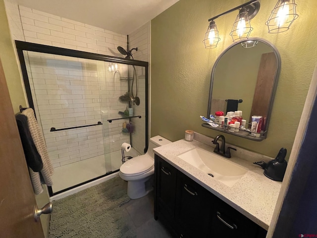 bathroom with vanity, toilet, and a shower with shower door