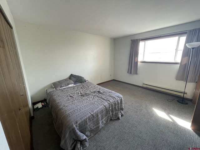 carpeted bedroom featuring a closet and a baseboard heating unit