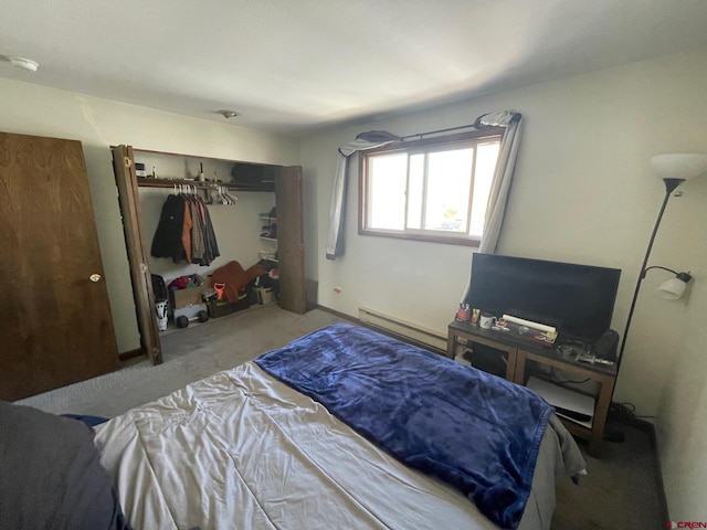 carpeted bedroom with a closet and a baseboard heating unit