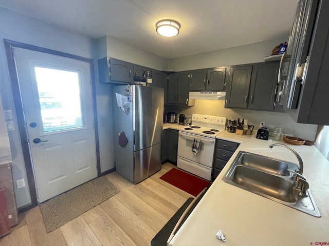 kitchen featuring stainless steel fridge, sink, a textured ceiling, white range with electric cooktop, and light hardwood / wood-style floors