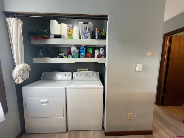 laundry room featuring light wood-type flooring and washer and clothes dryer