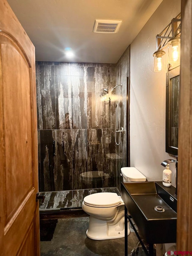 bathroom featuring toilet and tiled shower