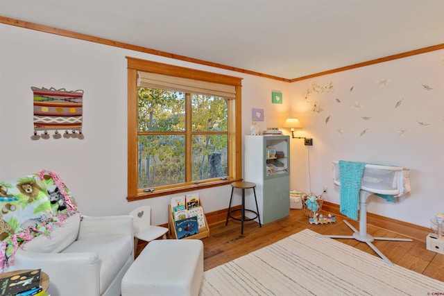 living area with hardwood / wood-style flooring and crown molding