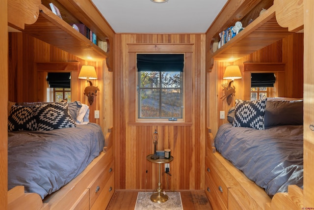 bedroom featuring wood-type flooring and wooden walls