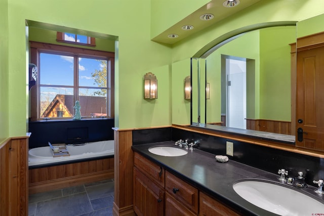 bathroom with a tub and vanity