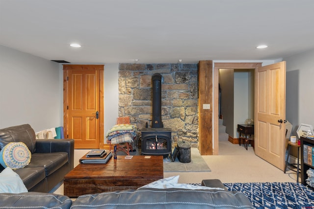 living room with a wood stove and light colored carpet