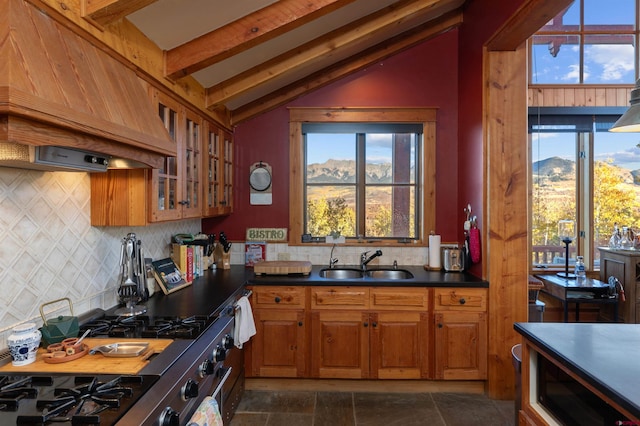 kitchen featuring lofted ceiling with beams, a mountain view, stainless steel stove, sink, and custom exhaust hood