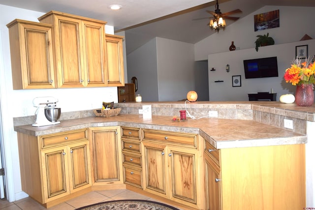 kitchen with kitchen peninsula, lofted ceiling, ceiling fan, and light tile patterned floors