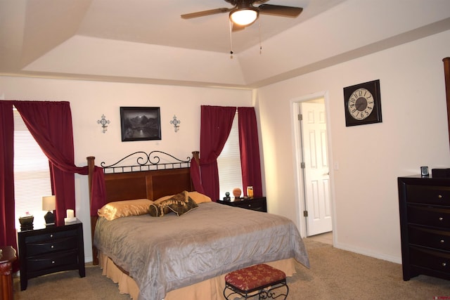 bedroom with ceiling fan, a tray ceiling, and carpet flooring