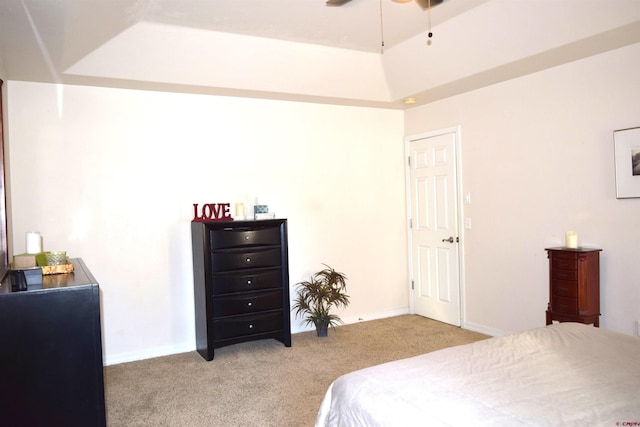 bedroom featuring ceiling fan, light carpet, and a tray ceiling