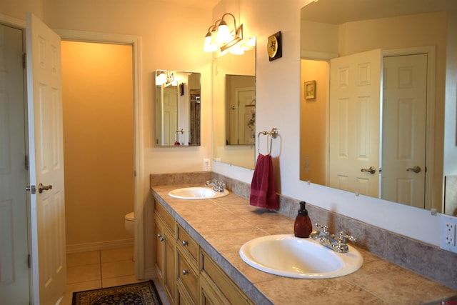 bathroom with tile patterned flooring, vanity, and toilet