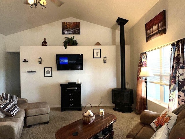 carpeted living room with lofted ceiling, ceiling fan, and a wood stove