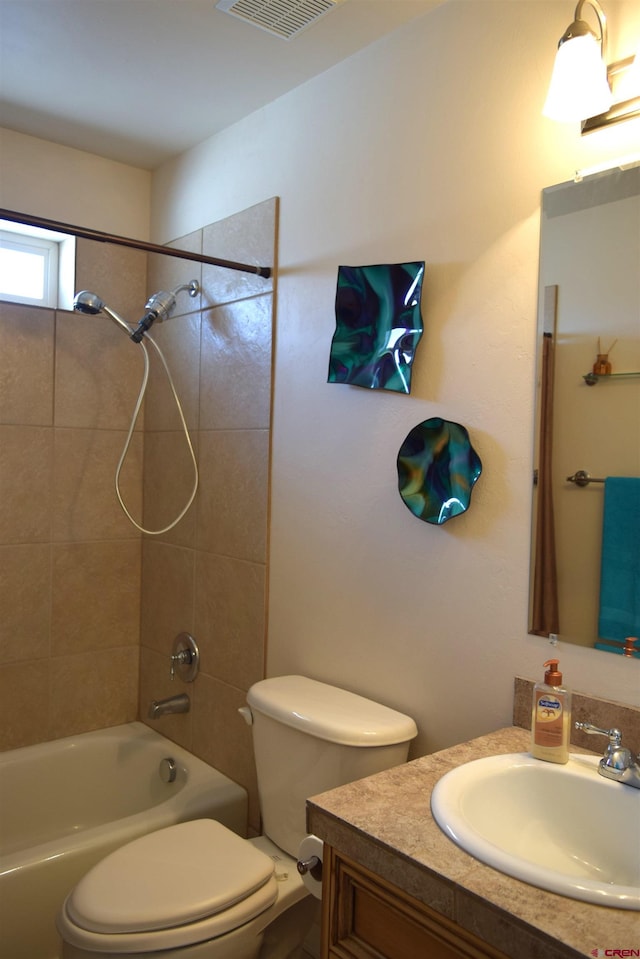 full bathroom with tiled shower / bath combo, vanity, and toilet