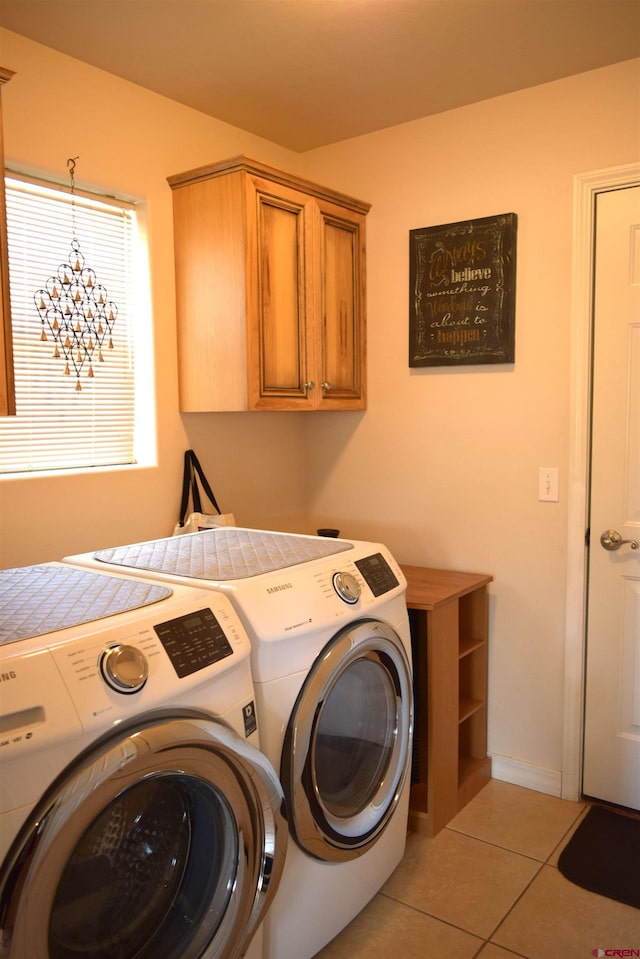 laundry room featuring cabinets, separate washer and dryer, and light tile patterned floors