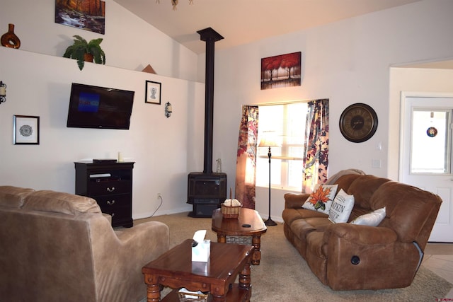 living room with light colored carpet, lofted ceiling, and a wood stove