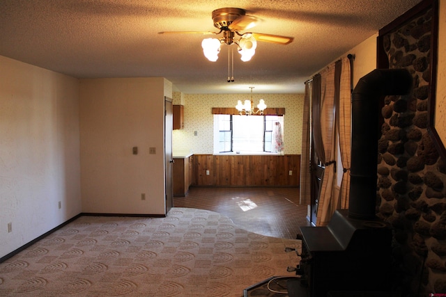 unfurnished room with light hardwood / wood-style flooring, ceiling fan with notable chandelier, and a textured ceiling