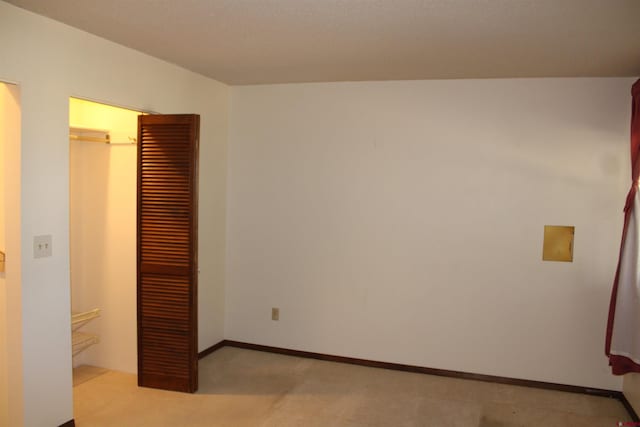 unfurnished bedroom with light carpet and a closet