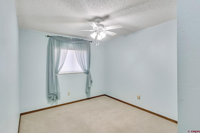 carpeted empty room with ceiling fan and a textured ceiling