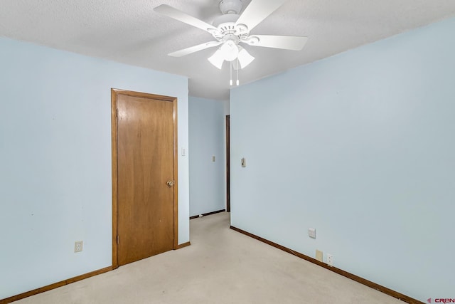 unfurnished bedroom with ceiling fan and a textured ceiling