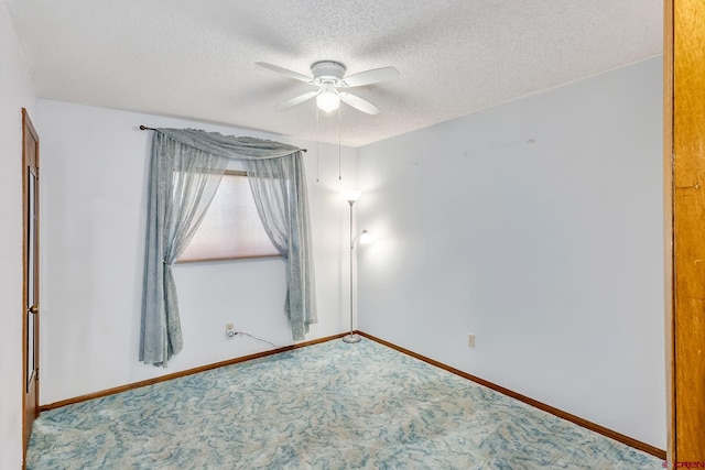 carpeted spare room featuring a textured ceiling and ceiling fan