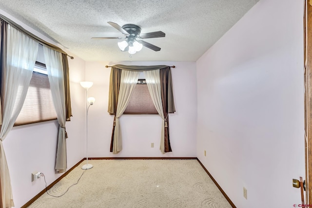 carpeted empty room featuring ceiling fan and a textured ceiling