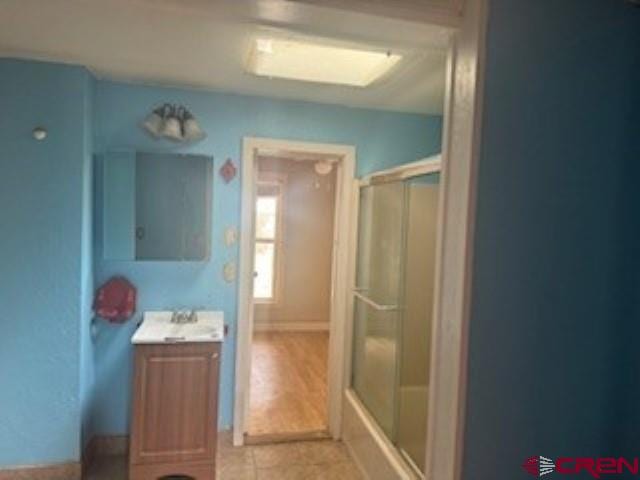 bathroom featuring vanity, hardwood / wood-style flooring, and shower / bath combination with glass door