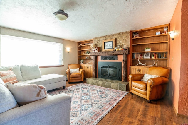 living room with dark hardwood / wood-style floors, a tiled fireplace, and a textured ceiling