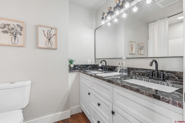 bathroom featuring toilet, hardwood / wood-style flooring, and vanity