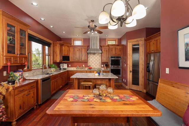 2239 Mockingbird Valley Ct, Durango, CO 81301 - kitchen featuring appliances with stainless steel finishes, wall chimney range hood, a sink, a kitchen island, and backsplash