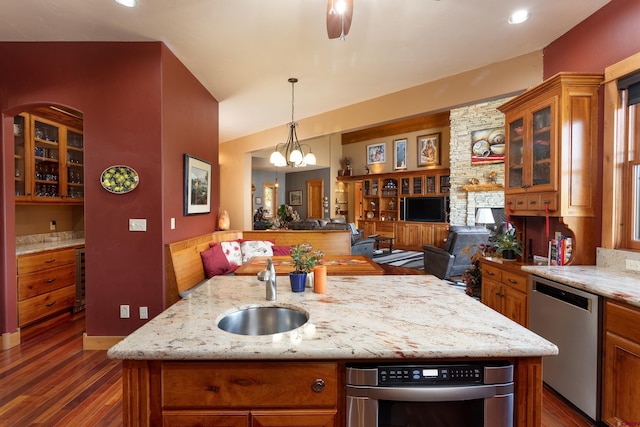 2239 Mockingbird Valley Ct, Durango, CO 81301 - kitchen with stainless steel dishwasher, a sink, open floor plan, dark wood finished floors, and brown cabinets