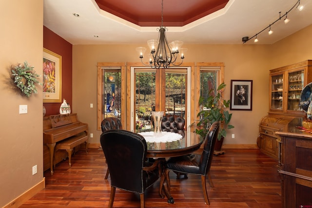 2239 Mockingbird Valley Ct, Durango, CO 81301 - dining area featuring a chandelier, dark wood-style flooring, baseboards, and a raised ceiling