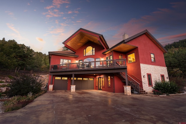 2239 Mockingbird Valley Ct, Durango, CO 81301 - view of front of home featuring stone siding, stairs, a chimney, concrete driveway, and a garage