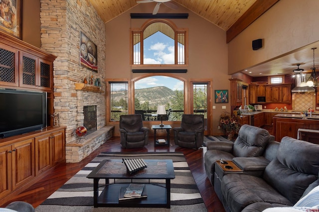 2239 Mockingbird Valley Ct, Durango, CO 81301 - living area featuring a ceiling fan, high vaulted ceiling, wood-type flooring, a stone fireplace, and wooden ceiling