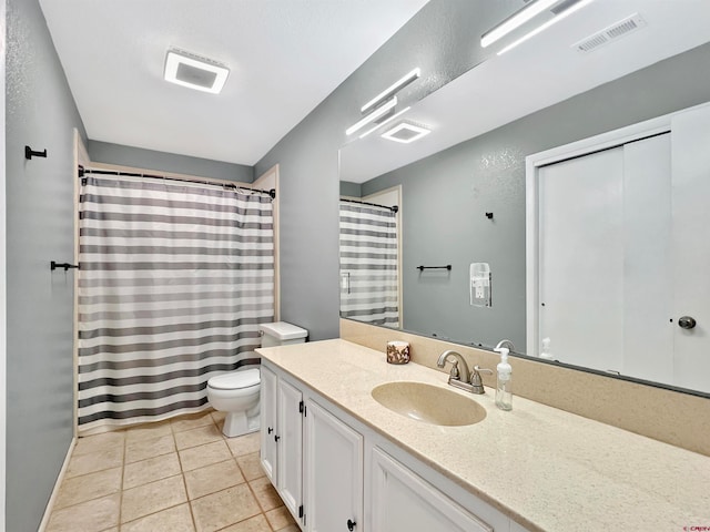 bathroom featuring walk in shower, vanity, toilet, and tile patterned flooring