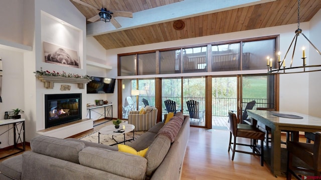 living room featuring wood ceiling, beam ceiling, high vaulted ceiling, ceiling fan with notable chandelier, and light hardwood / wood-style floors