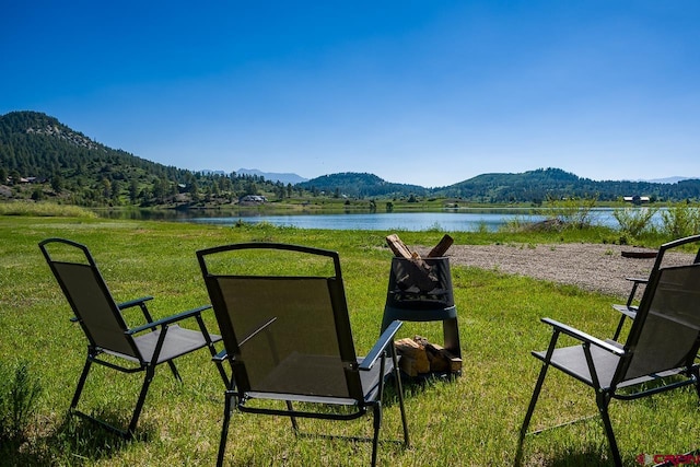 view of yard featuring an outdoor fire pit and a water and mountain view