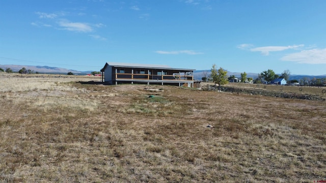 back of property featuring a rural view and a mountain view