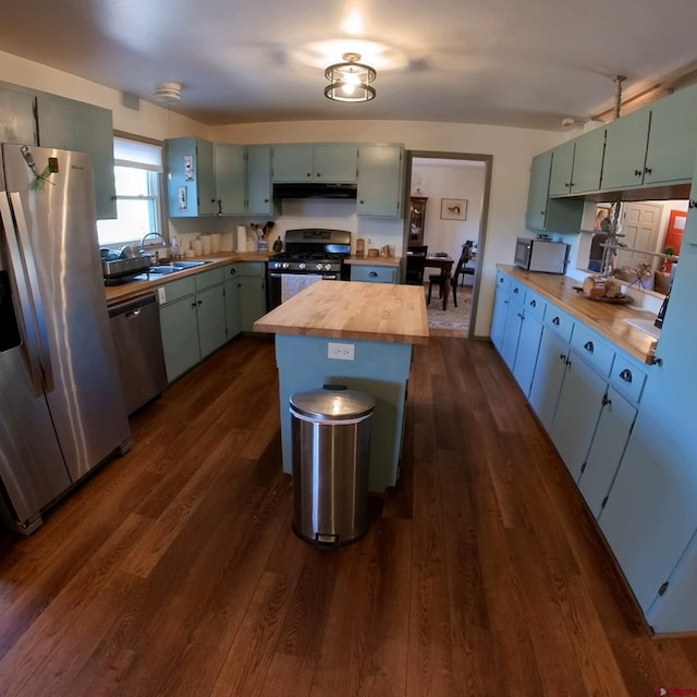 kitchen featuring a center island, appliances with stainless steel finishes, dark hardwood / wood-style floors, and wood counters