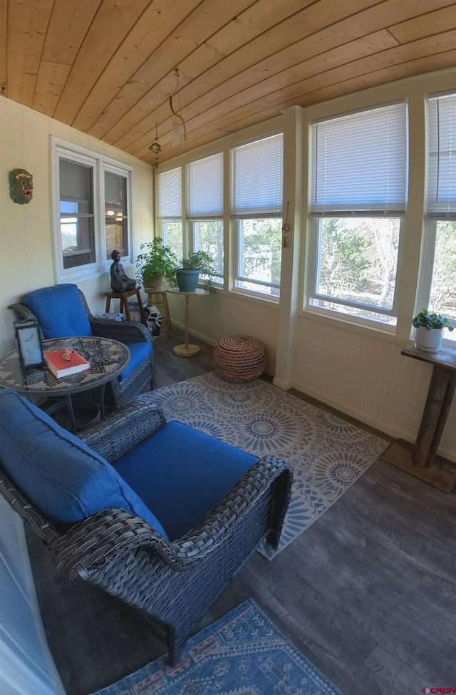 sunroom / solarium featuring a healthy amount of sunlight, wooden ceiling, and vaulted ceiling