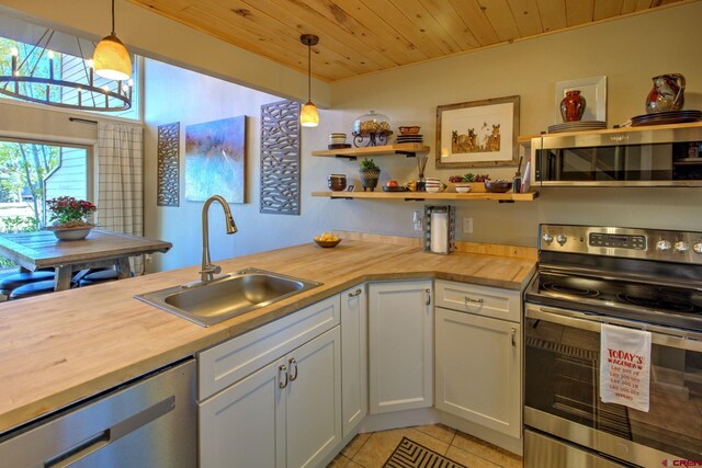 33 Davis Cup Unit 4008, Pagosa Springs, CO 81147 - kitchen featuring stainless steel appliances, butcher block counters, a sink, light tile patterned floors, and wood ceiling
