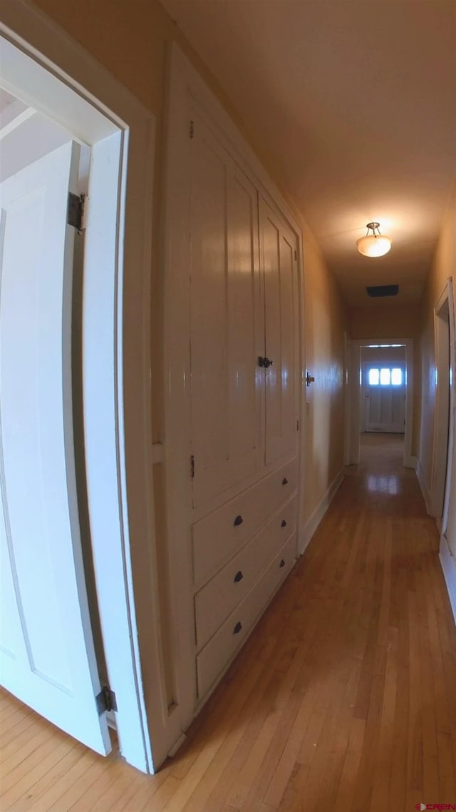 corridor with light hardwood / wood-style floors