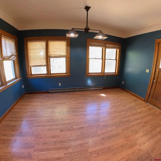 interior space featuring baseboard heating, hardwood / wood-style flooring, and plenty of natural light