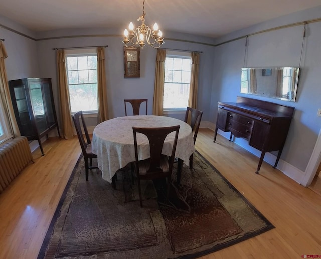 dining area featuring light hardwood / wood-style floors, a notable chandelier, and plenty of natural light