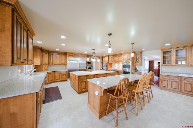 kitchen featuring sink, hanging light fixtures, a large island, a kitchen breakfast bar, and stainless steel appliances