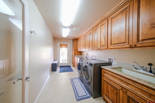 laundry room featuring cabinets, sink, washing machine and clothes dryer, and light tile patterned floors