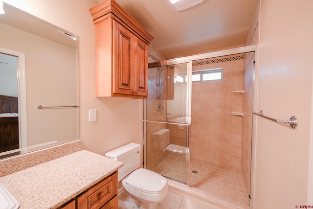 bathroom featuring toilet, a shower with shower door, vanity, and tile patterned floors